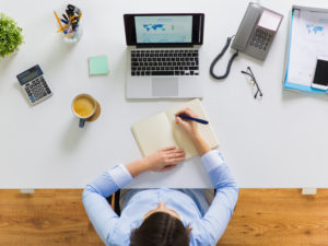 businesswoman writing to notebook at office